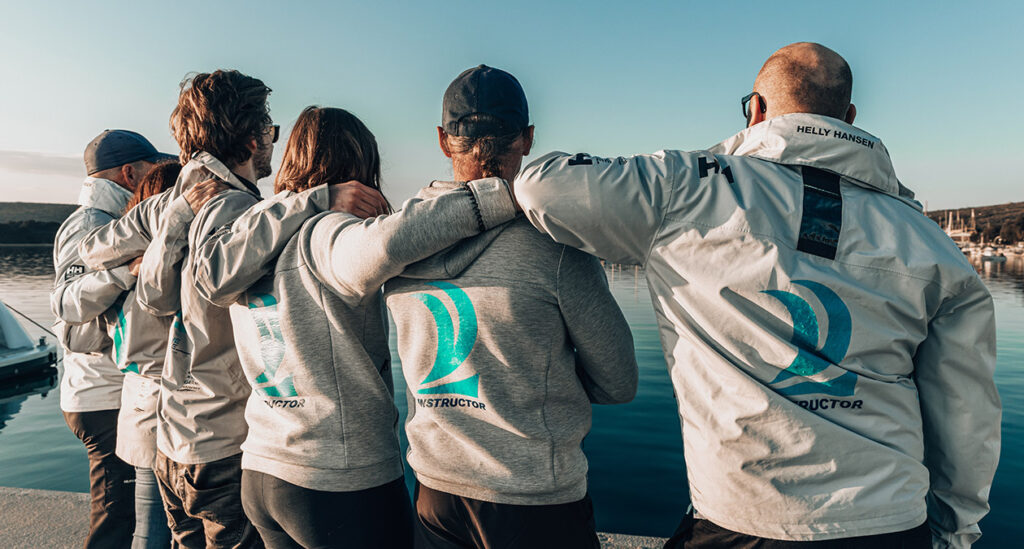 IN2THEBLUE trainer team in team jackets on the pontoon in Punat