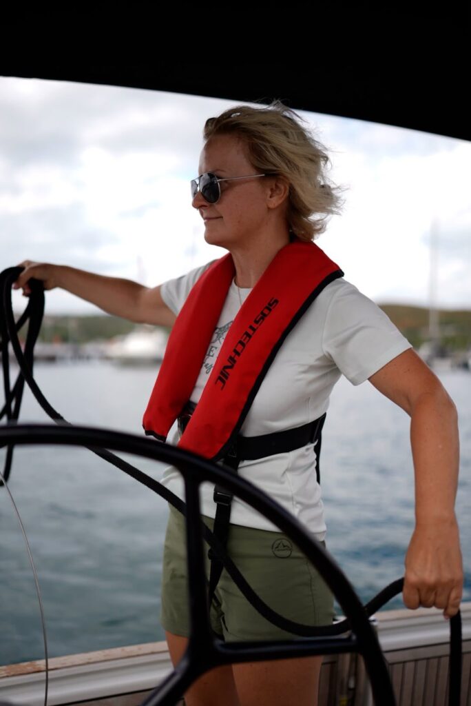 Participant in the Ladies Only Skipper Training steers a sailing yacht in the harbour of Punat