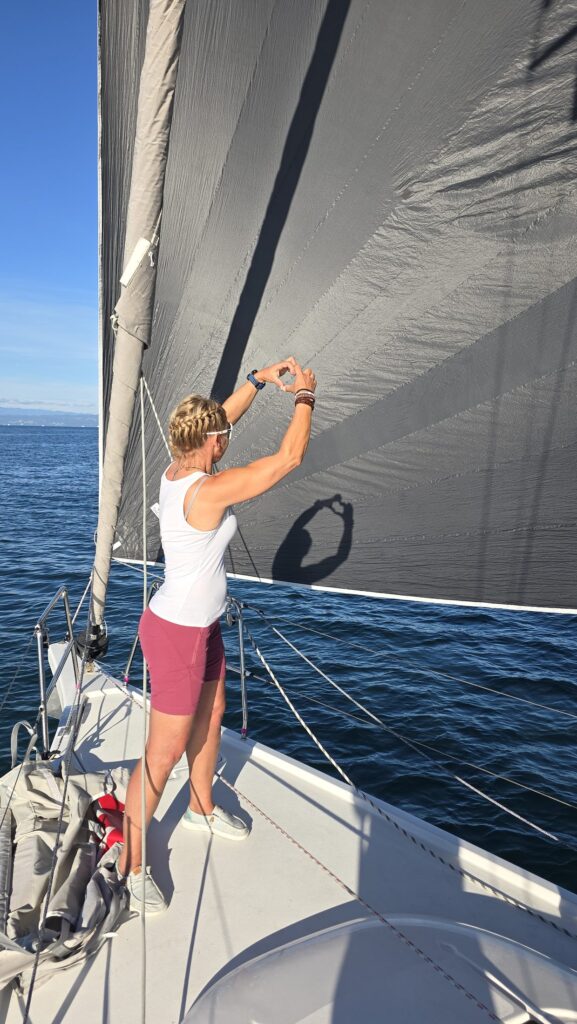 Sailor checks the mainsail at the mast of a yacht