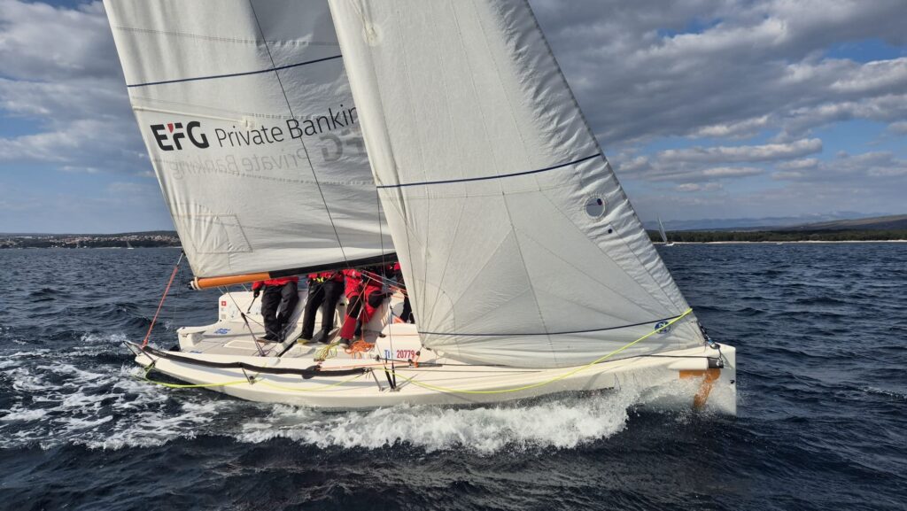 Crew beim Regattatraining in Punat an der Kante einer Yacht am Wind